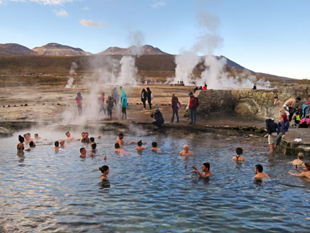 Swimmers feel the contrast of hot water and freezing cold air at El Tatio geyser field, Andes Mountains, Chile.