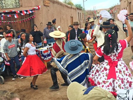 A parade celebrating Chilean Independence Day stops for a round of dancing in the streets of San Pedro de Atacama, Chile.