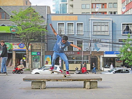 A skateboarder tackles a makeshift bench at Plaza Avaroa in La Paz, Bolivia.