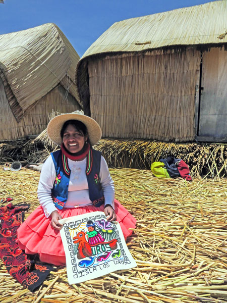 A woman holds a pillow case that I bought on the Uros Islands near Puno, Peru.