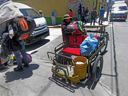 A bicycle taxi driver lifts a load in Yunguyo, Peru.
