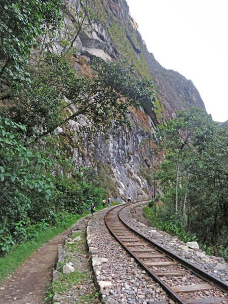 Temporary hobos walk along the train tracks in between Hidroelectrica and Aguas Calientes, Peru.
